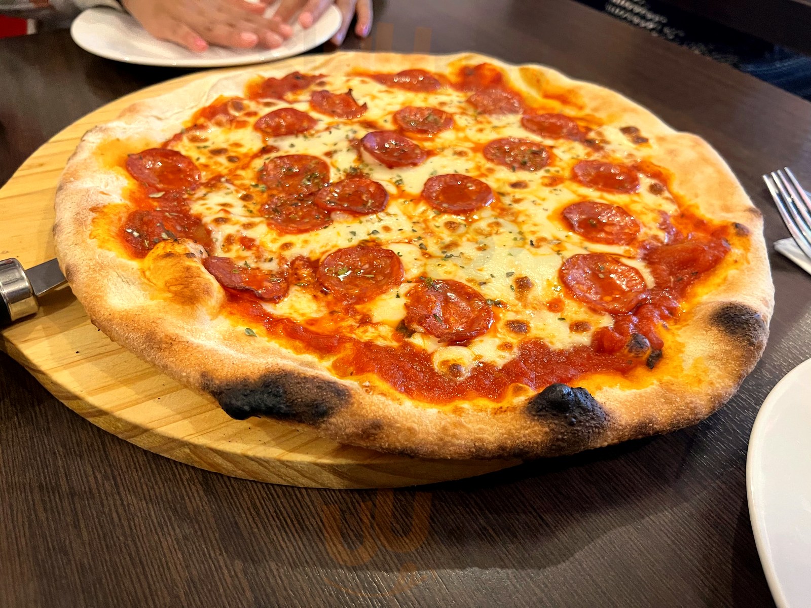 Pepperoni pizza on a wooden board at Il Piatto